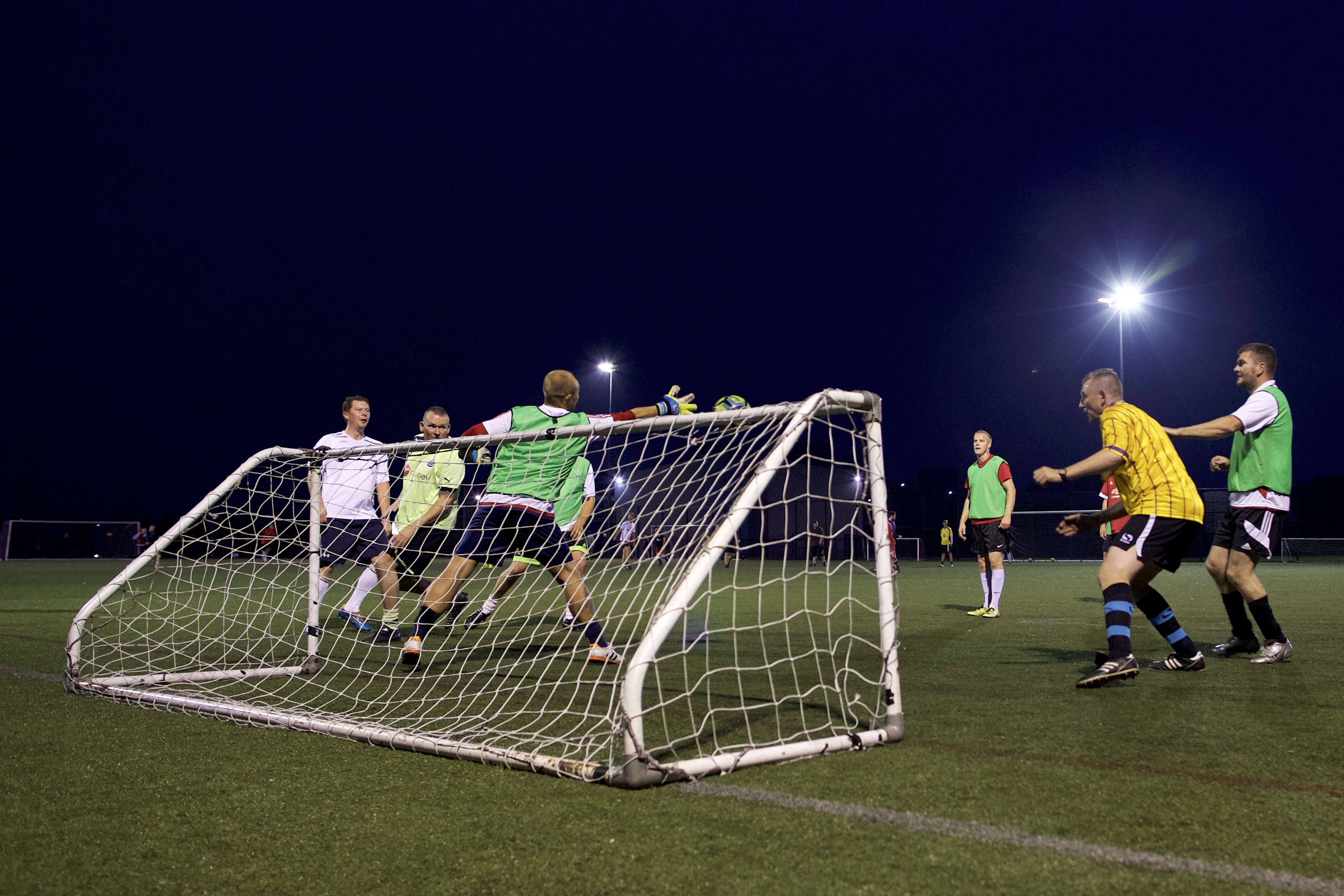 People playing football scoring a goal