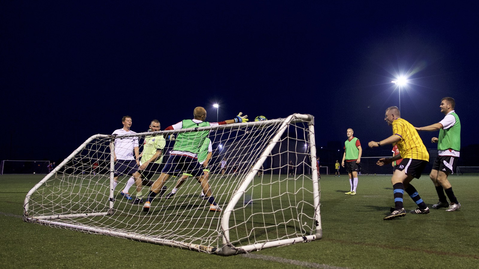 People playing football scoring a goal